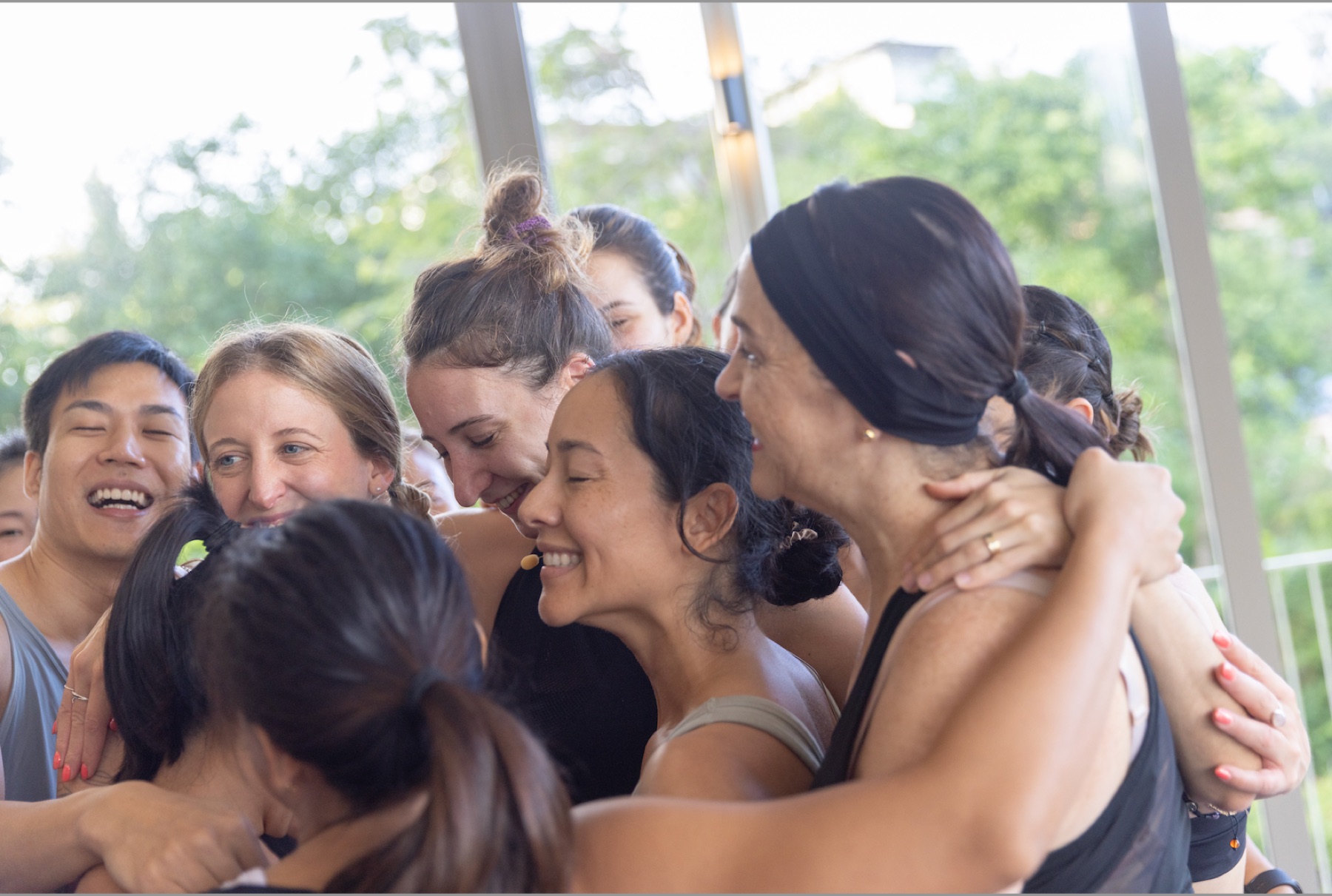 Aligned Yoga trainees embracing at the end of an in-person training